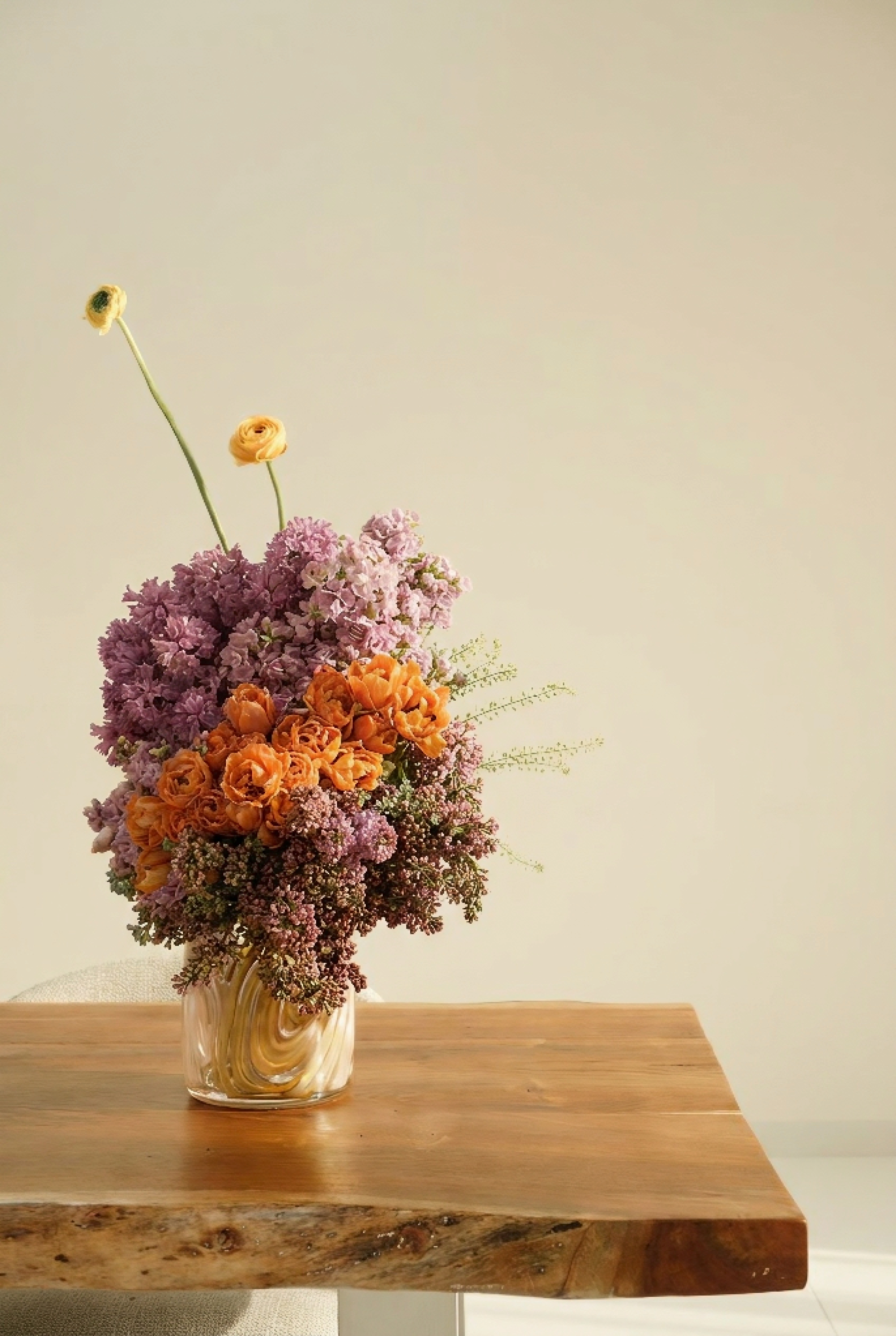 Purple and Orange Floral Arrangements in Tinted Glass Vase