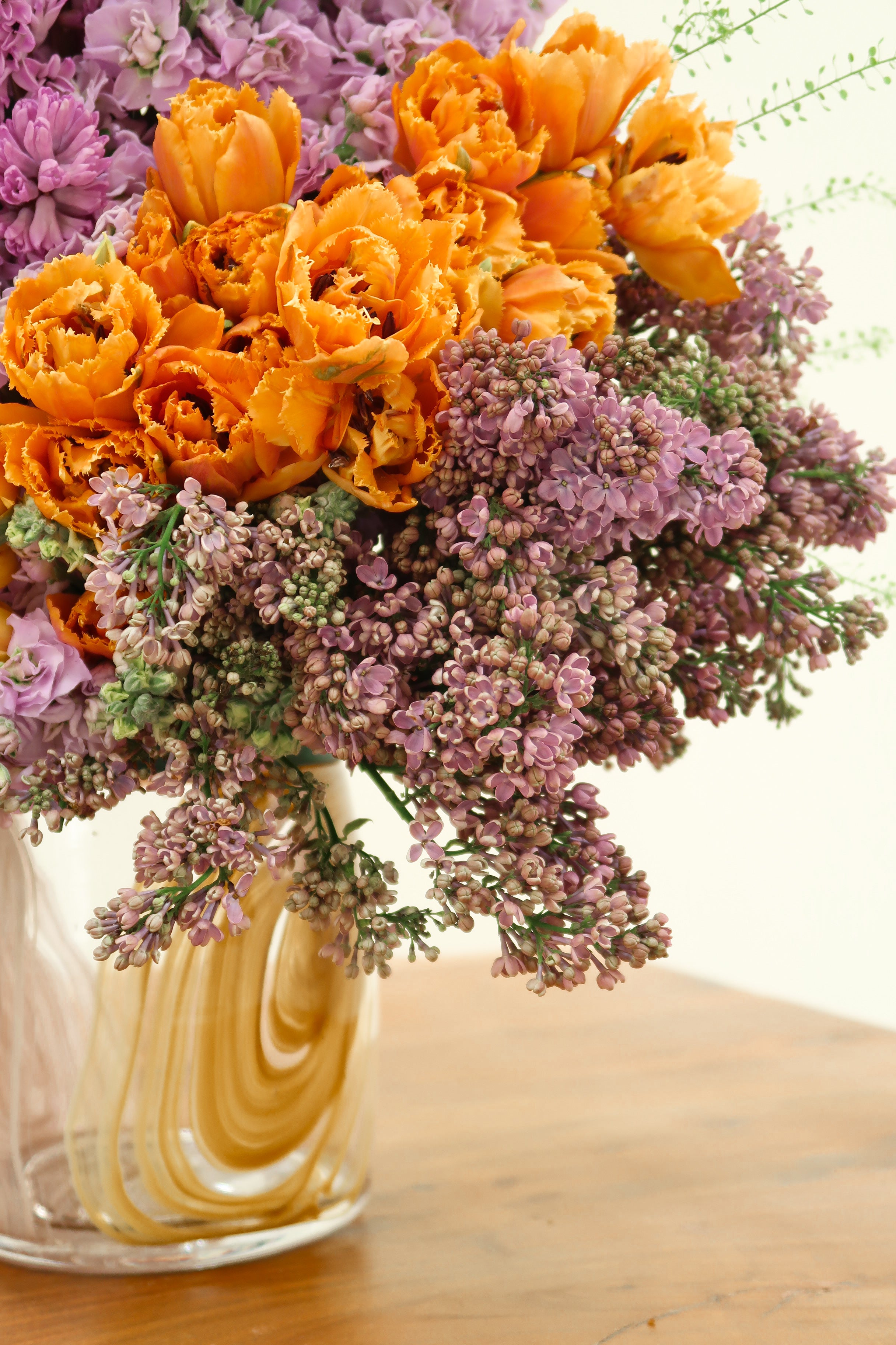 Purple and Orange Floral Arrangements in Tinted Glass Vase